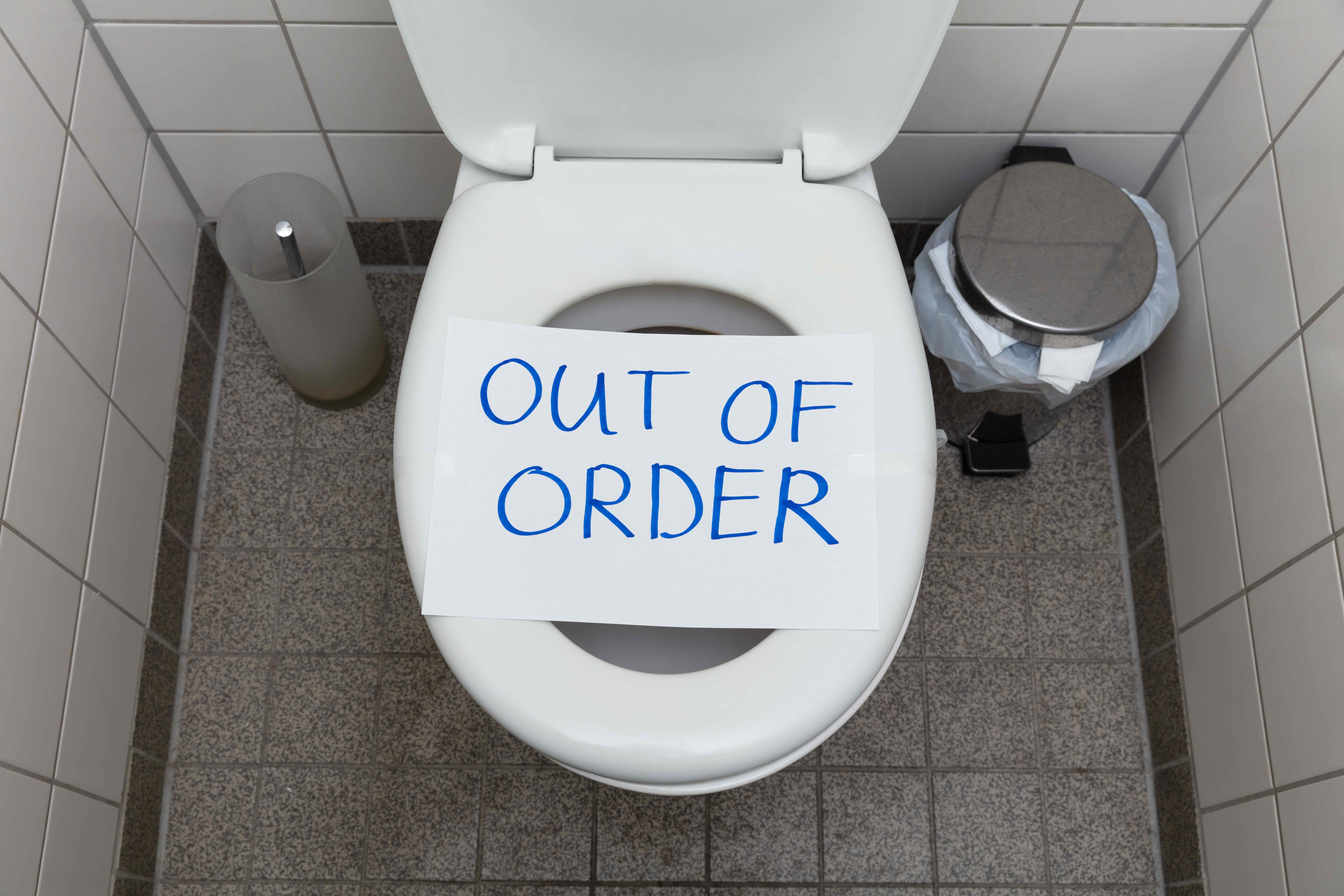 Written Text Out Of Order Message On Paper Over Toilet Bowl In Bathroom